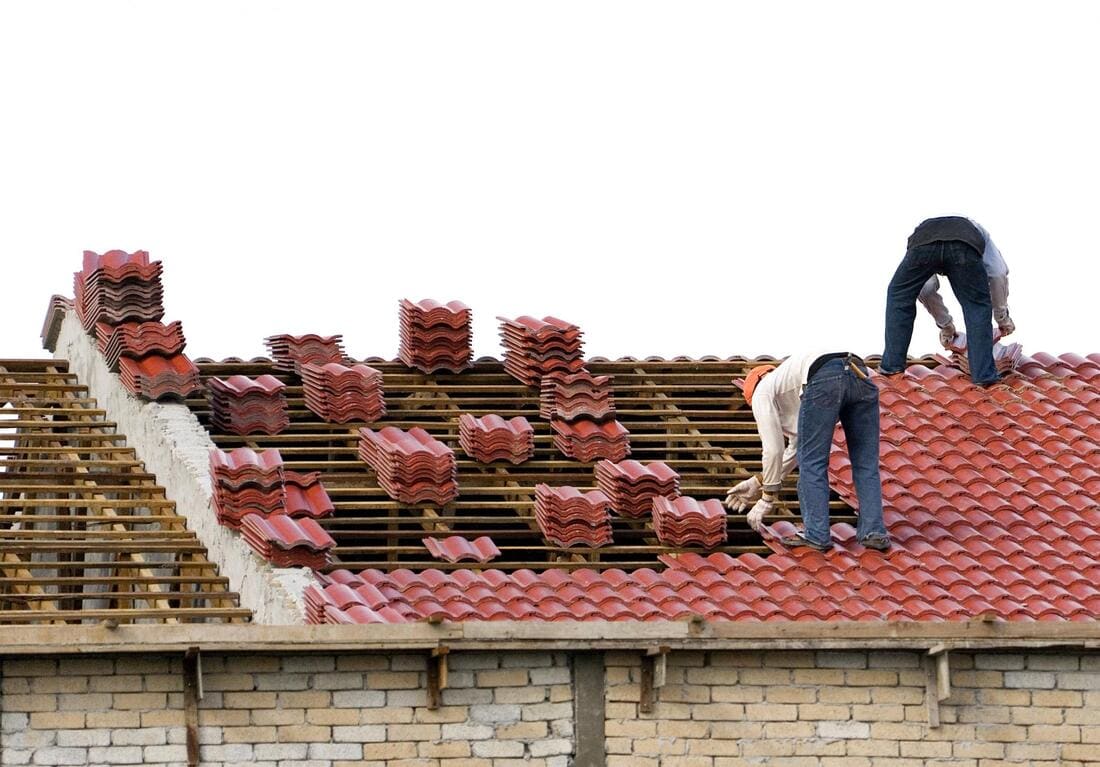Crew installing new tile roofing on battens